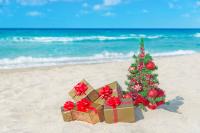 a christmas tree with gifts on the beach 